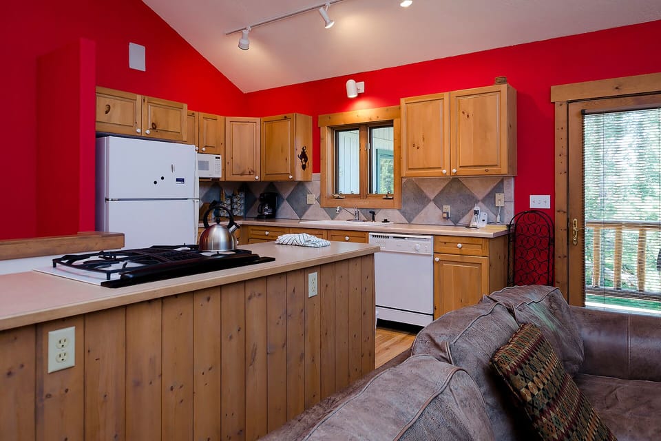 Cook your favorite meals in this fully equipped kitchen featuring warm wood cabinets, modern appliances, and a cozy breakfast bar.