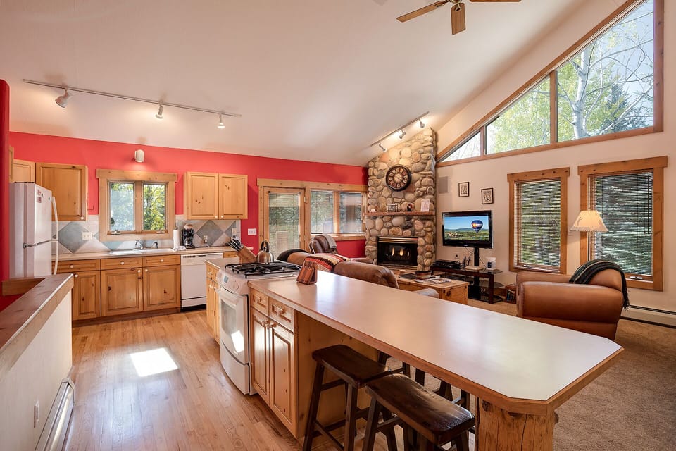 Gather in your spacious open-concept living area where the kitchen island becomes your social hub, warmed by a stunning stone fireplace.