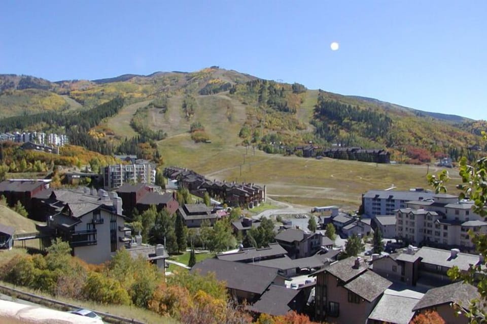 Scenic mountain resort area with autumn foliage and ski slopes visible in the background.