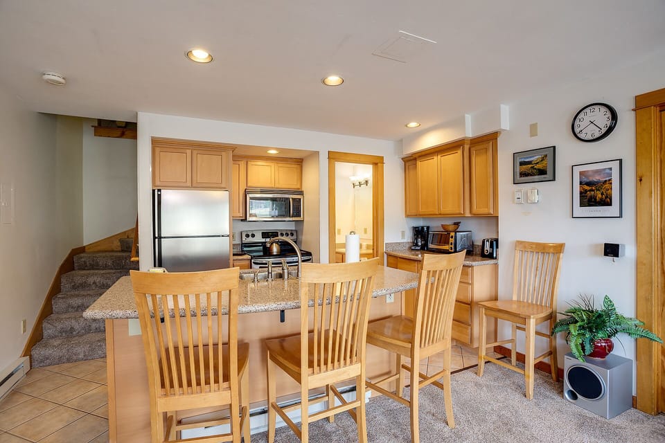 Your open kitchen and dining space features warm wood cabinets, granite counters, and stainless steel appliances—perfect for preparing meals together.