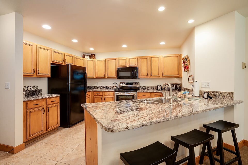 Your fully equipped kitchen features granite countertops, modern appliances, and breakfast bar seating—perfect for cooking memorable meals together.