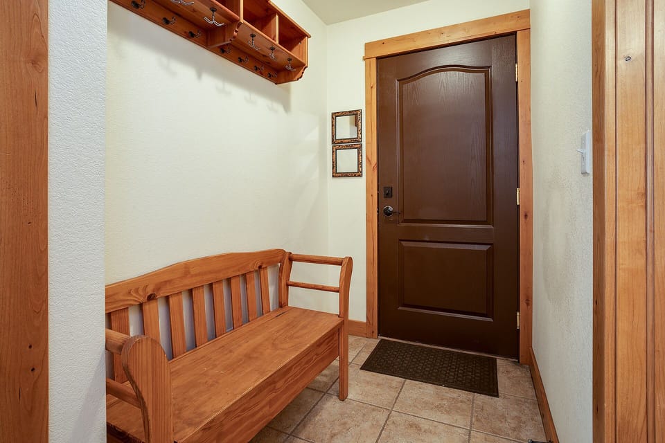 Your private entryway welcomes you with warm wood accents and a cozy bench—perfect for settling in after mountain adventures.