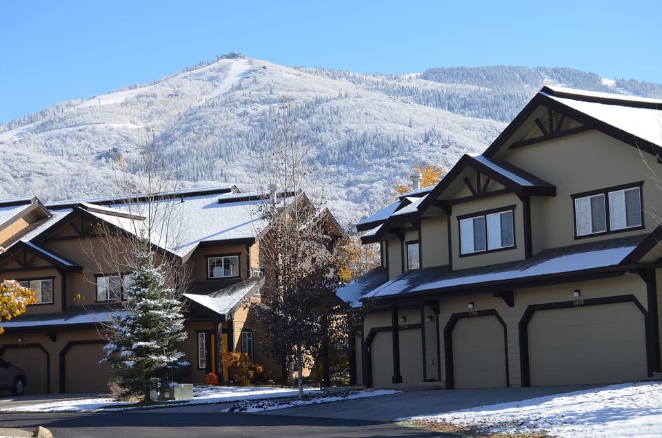 Mountain community with snow-dusted homes nestled against dramatic alpine backdrop and pristine winter landscape.