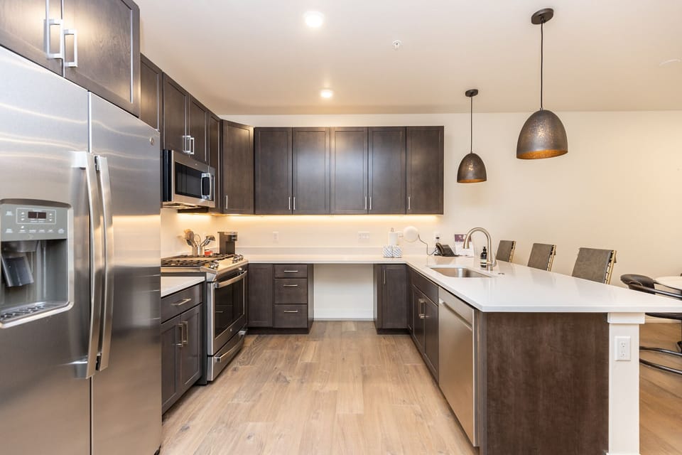 Your sleek kitchen features rich dark cabinetry, gleaming countertops, and premium stainless appliances perfect for creating memorable meals during your stay.