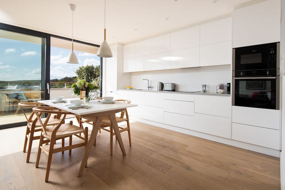 7 The Bay, Coldingham - immaculate single-wall kitchen with Neff appliances and a dining table to seat four