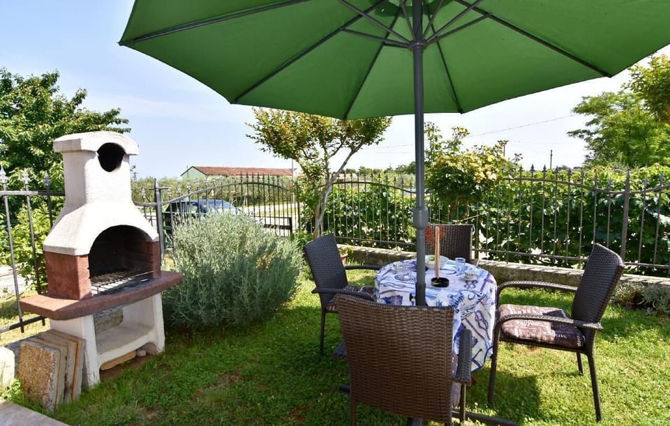 The private terrace equipped with a barbecue, umbrella, garden table and chairs