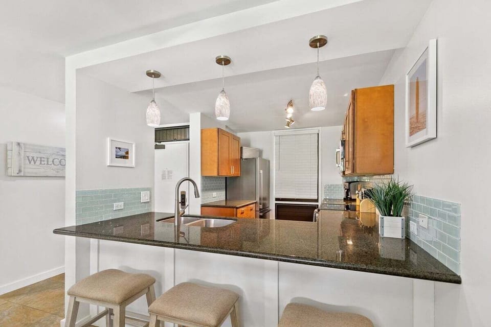 Spacious kitchen features granite countertops, pendant lights, and a breakfast bar for relaxed dining
