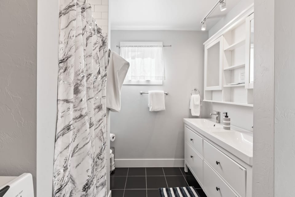 Master bathroom with a walk-in shower, toilet, and two person vanity. 