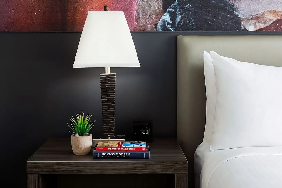 Unwind beside warm lighting with bedside essentials within reach.