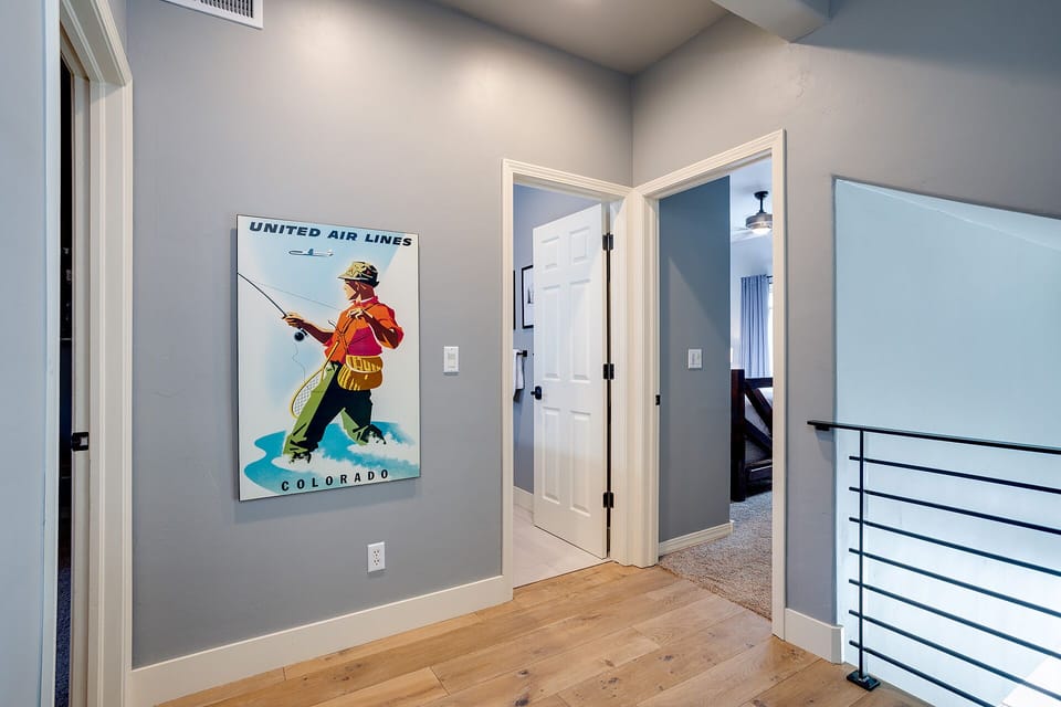 Step into your modern hallway where vintage travel art meets sleek design—your gateway to relaxation awaits.