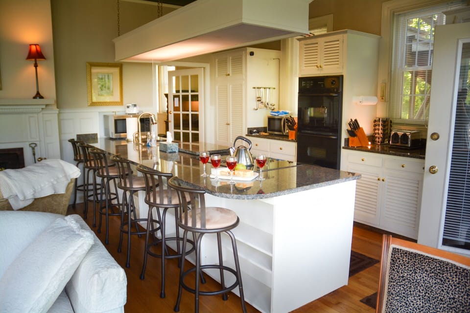 Kitchen w/ granite counters, vintage cabinets, double oven, microwave & fridge.