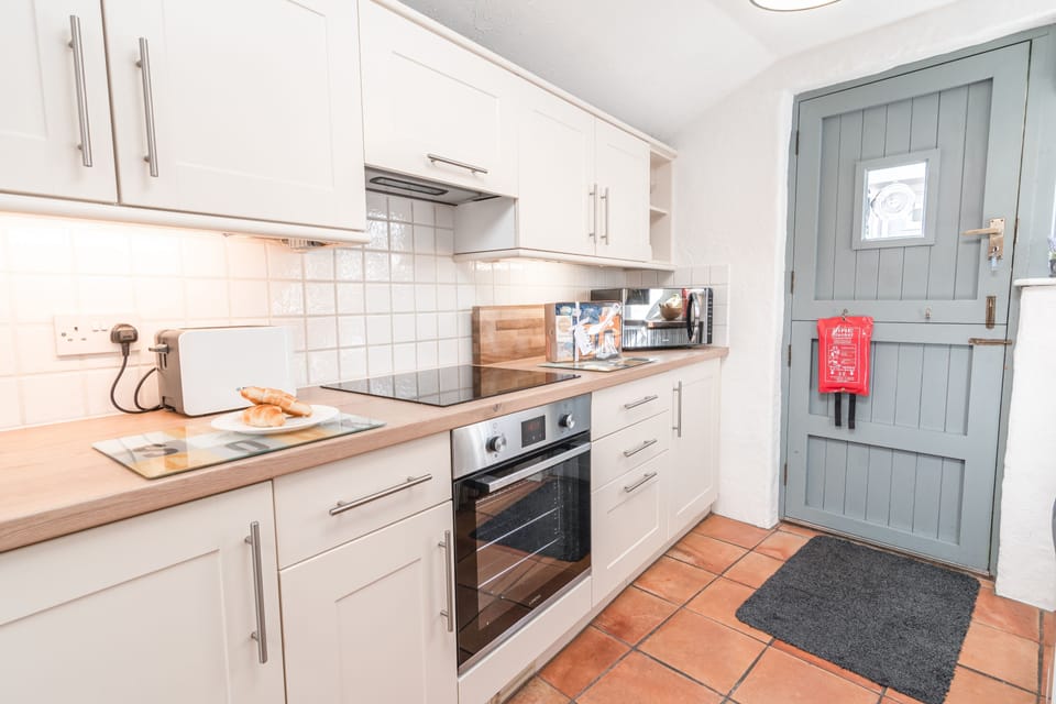 Salty's Cottage, St Agnes. Ground floor: Kitchen with a four-ring induction hob, electric oven, microwave, fridge and dishwasher