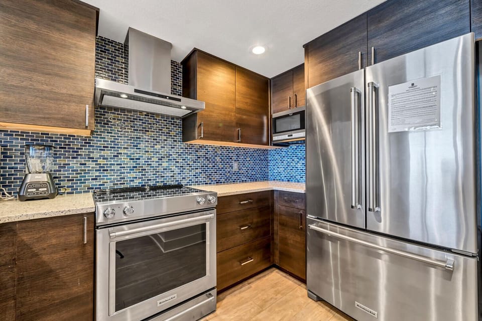 Your fully equipped kitchen features premium stainless steel appliances and stunning mosaic tile backsplash for memorable meal preparation.