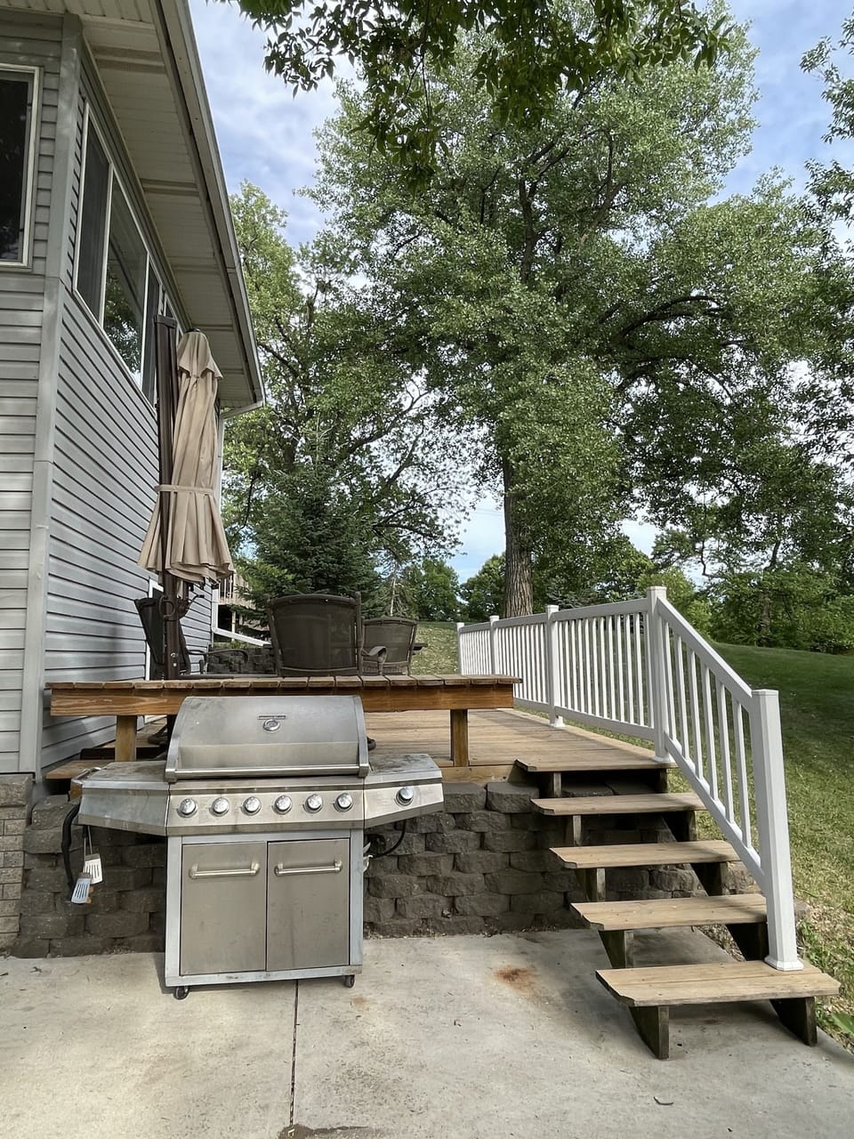 Deck with seating and umbrella for shade. 