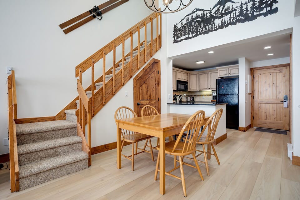 Your cozy mountain retreat features warm wood details and an open dining area where you'll enjoy meals together.
