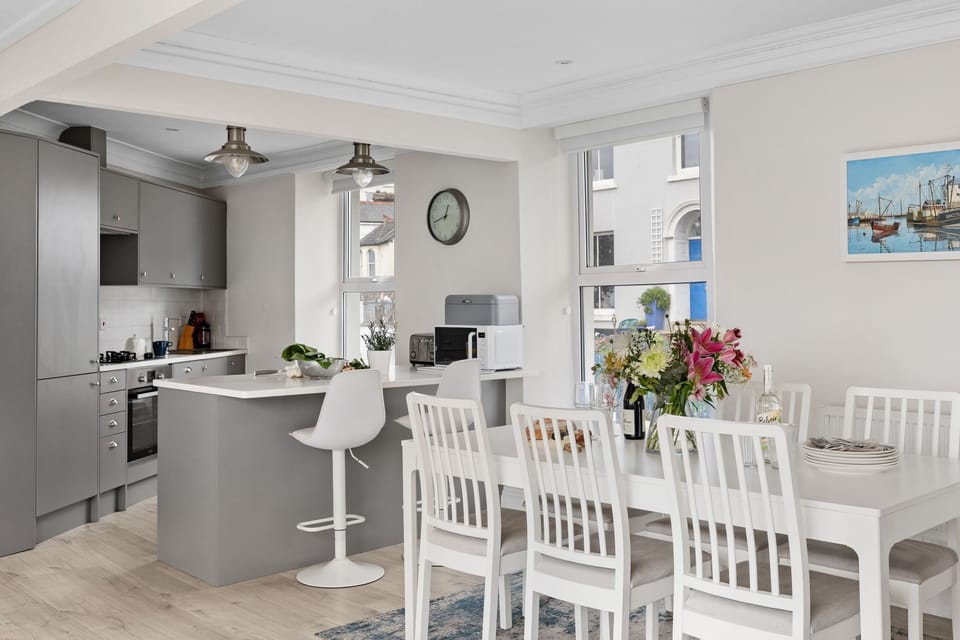 Dining table in open plan living space, fridge, freezer, cooking facilities - Kings Quay