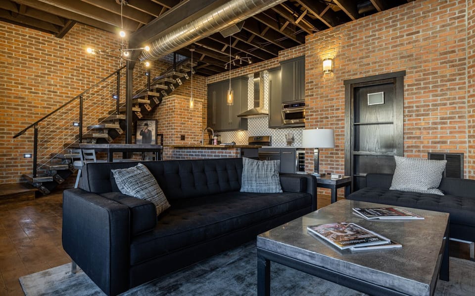 The open living and kitchen space has an industrial steel floating stairway to 2nd level