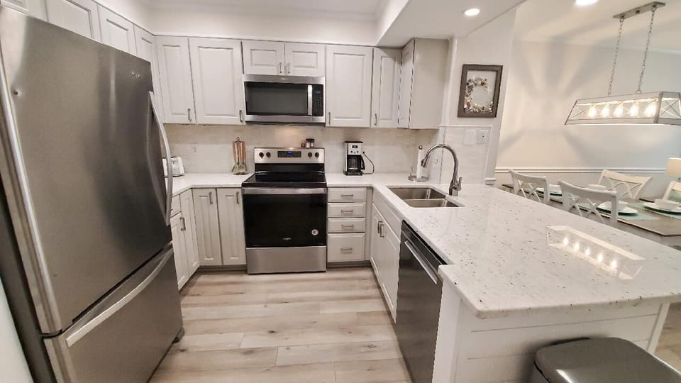 Kitchen is fully equipped with cookware, appliances, and place settings.