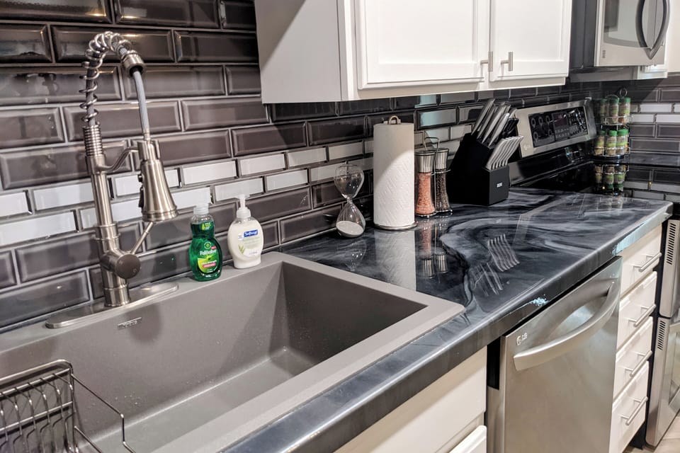 Deep sink, commercial pull-down faucet, marbled epoxy counters. Clean, modern.