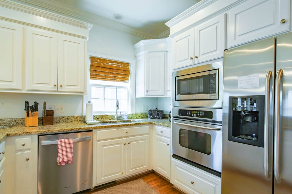 There is a dishwasher, oven, refrigerator, microwave and toaster.