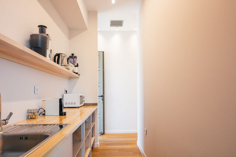An auxiliary pantry space can be found behind the kitchen, featuring a wine cooler!