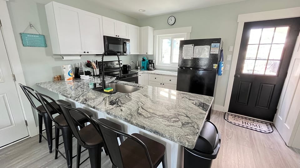 Full kitchen with full sized fridge/freezer, oven/stove, dishwasher, microwave