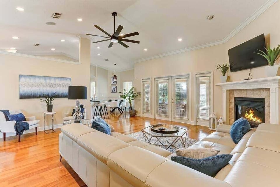 Massive, modern L-shaped leather couch, smart TV, high ceilings with plenty of space. Fireplace is not in use.