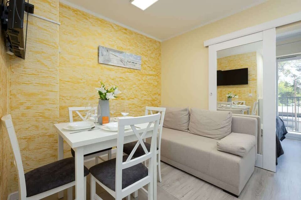 Another angle of the living room showing the yellow walls, a small coffee table, and a cozy couch.
