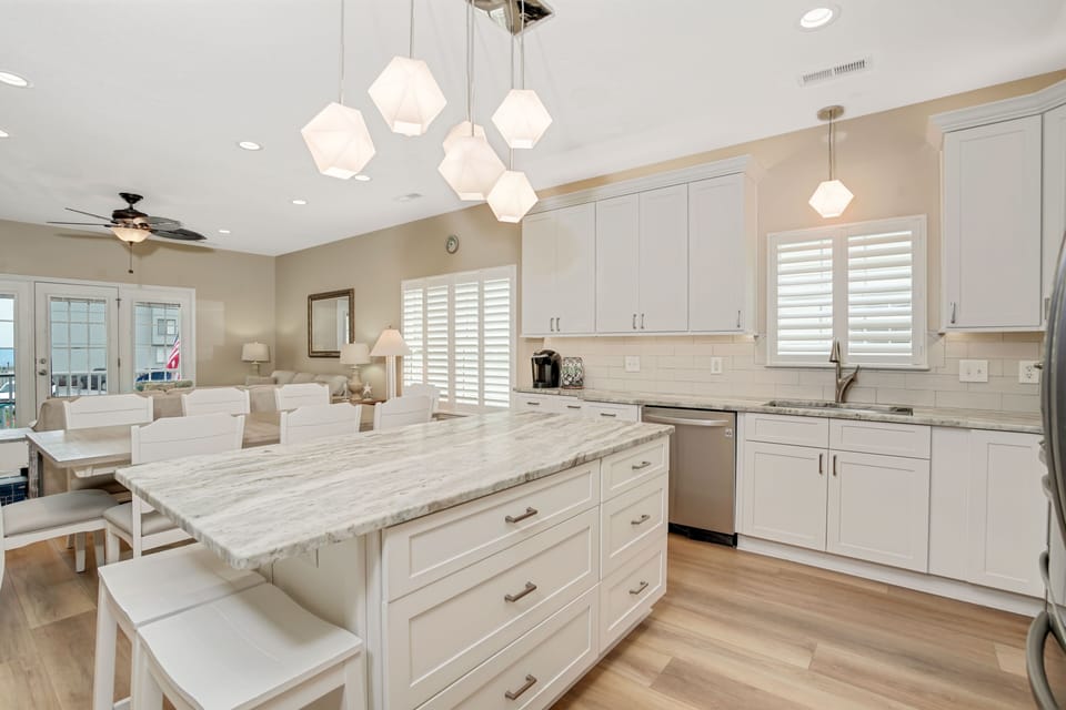 Your gourmet kitchen awaits with marble countertops, geometric pendant lighting, and premium appliances—perfect for creating memorable meals together.