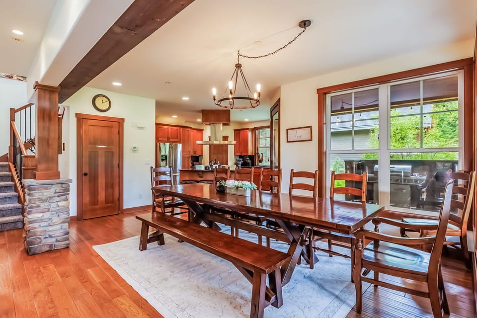 Spacious dining room with farmhouse table, bench seating, and large windows.