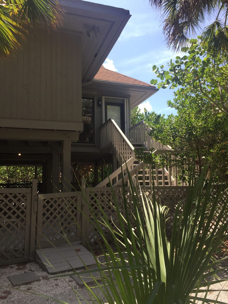 Fenced in entertainment space with outside shower and patio area with grill