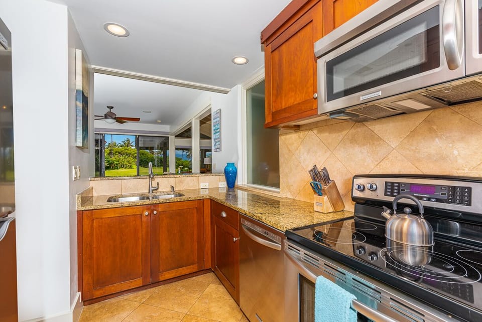 Spacious kitchen featuring ample counter space, modern appliances, and a large window with garden views.