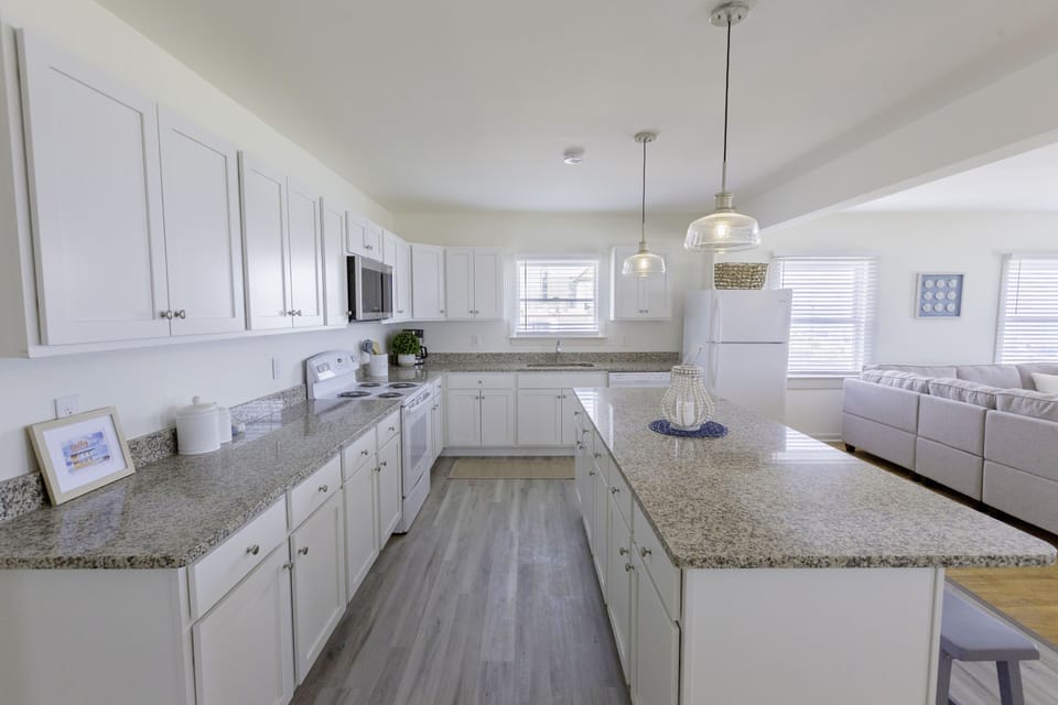 Kitchen with stove, microwave, dishwater and full-size refrigerator.