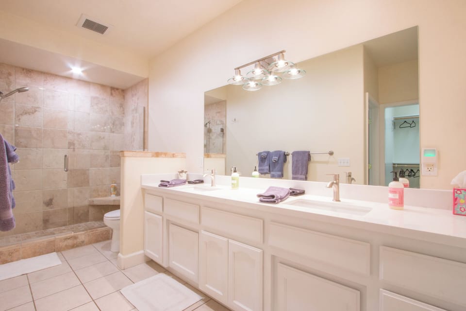 A spacious bathroom with a double vanity and a separate walk-in shower.
