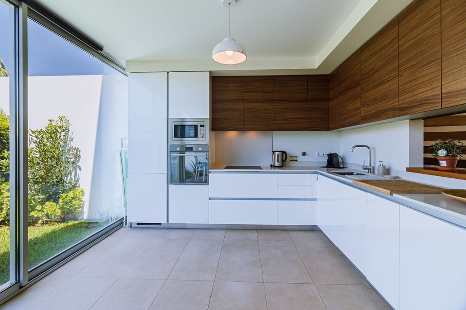 Modern white kitchen with wooden upper cabinets — Villa Blue Sagres D, holiday villa in Vila do Bispo