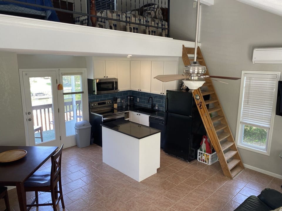 Open concept kitchen and living room. Ladder steps lead to sleeping loft. 