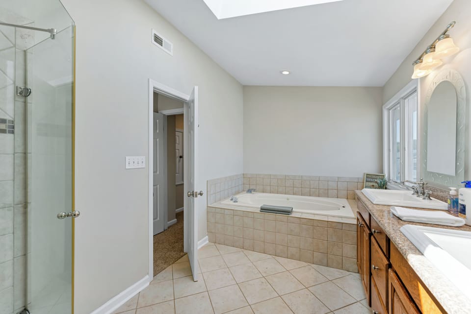 Spacious primary bathroom with dual vanity and soaking tub