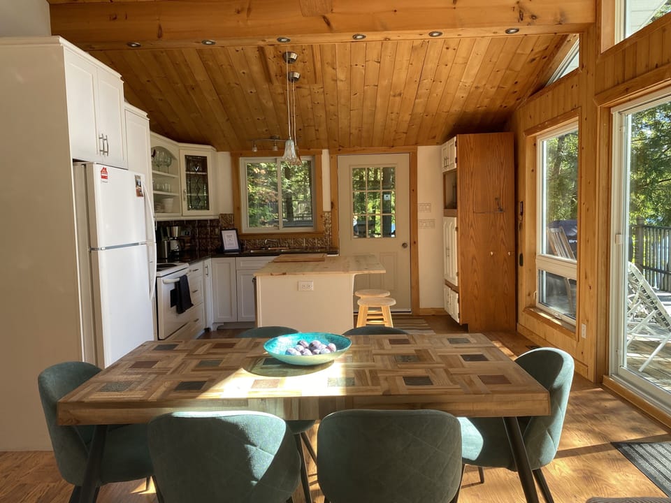 Bright open concept kitchen/dining/living area with floor to ceiling windows