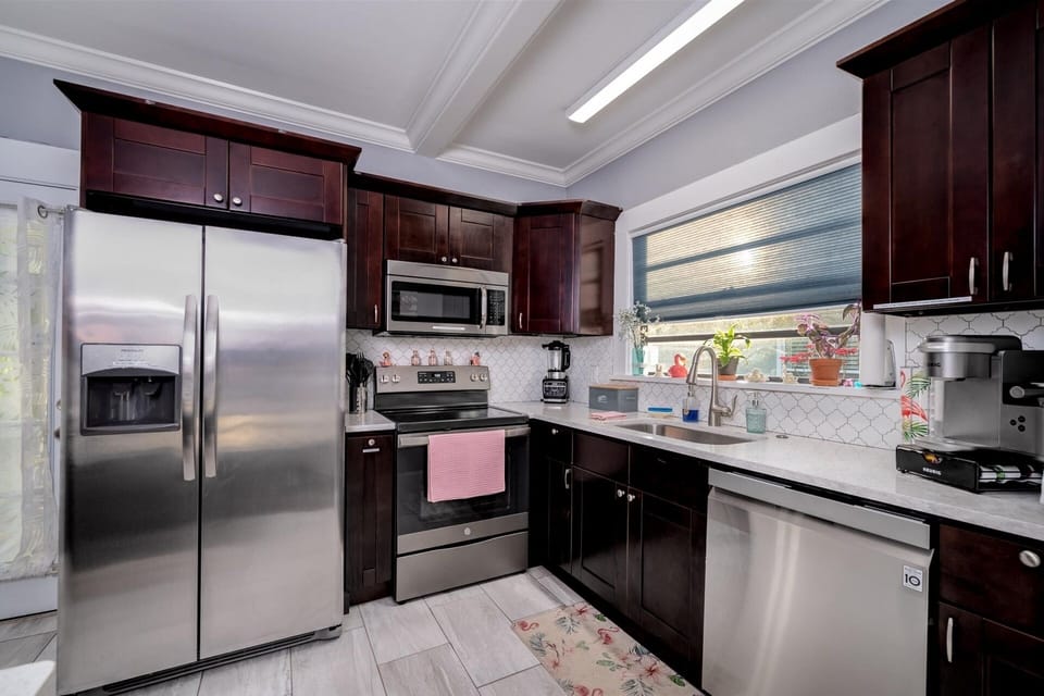 Kitchen complete with stainless steel appliances, dining area and desk area. 