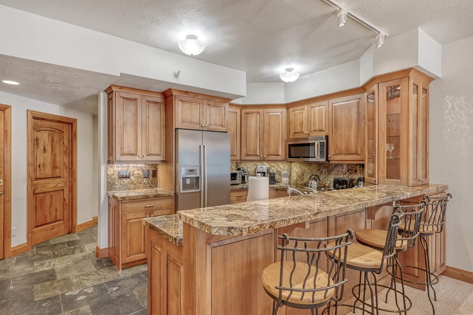 Your spacious kitchen features warm wood cabinetry, granite countertops, and stainless steel appliances—perfect for preparing memorable meals during your stay.