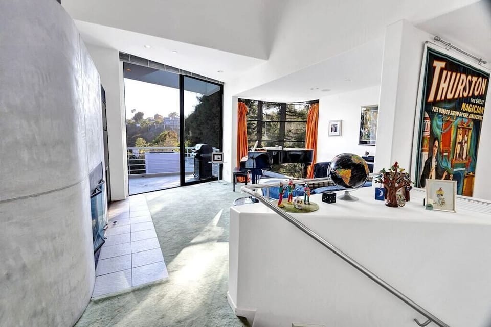 Living room area with grand piano, flat screen TV, fireplace and cushy sofa