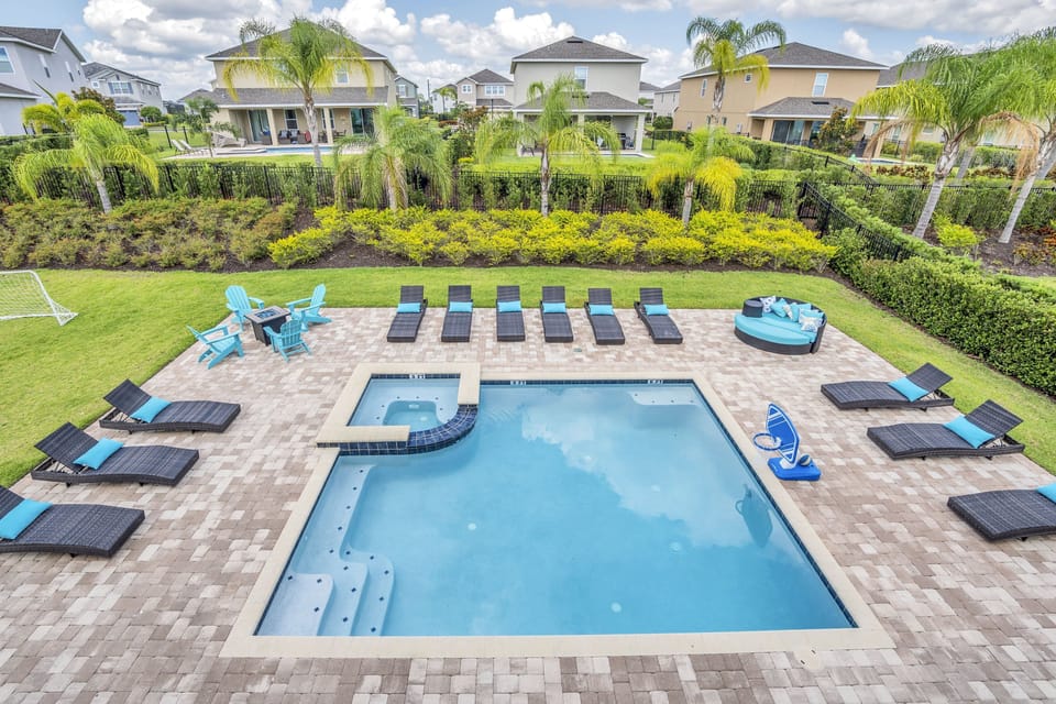 This aerial view highlights the layout, showcasing ample lounge space, a spa, and a well-planned backyard oasis.