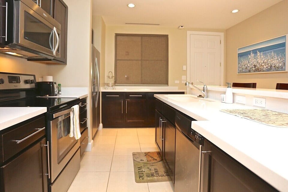 The modern kitchen has full-sized, stainless steel appliances including a dishwasher.