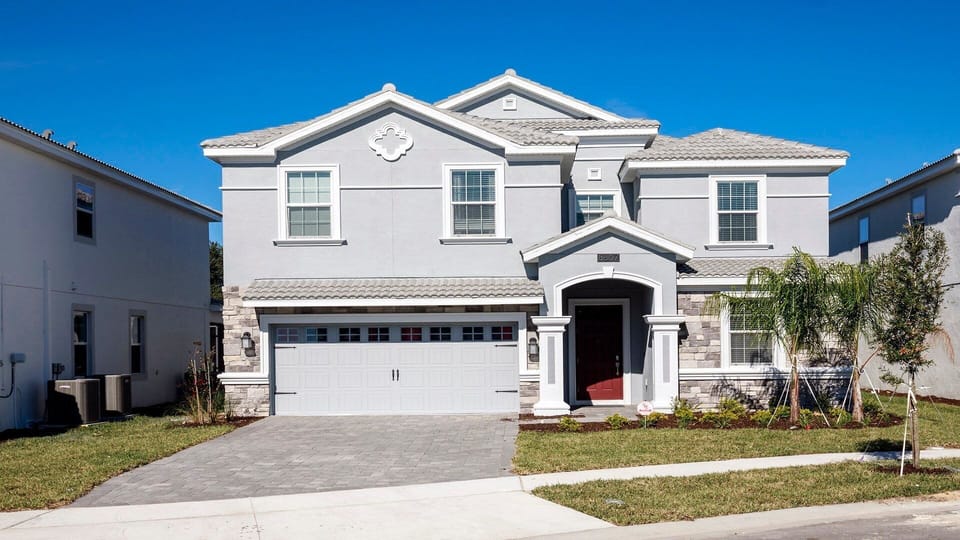 Spacious modern home with stylish facade, garage, and palm-lined front yard.