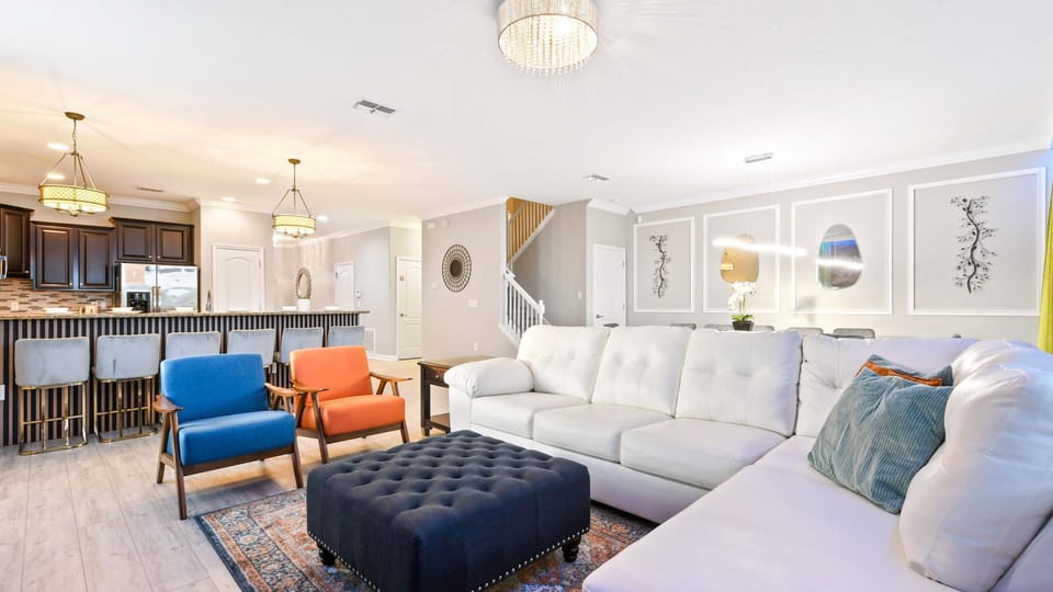 Elegant open-concept living area with stylish seating, modern kitchen, and chic lighting fixtures.