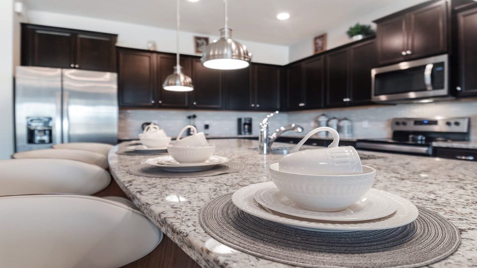 Elegant kitchen with granite countertops, dark cabinets, and modern decor.