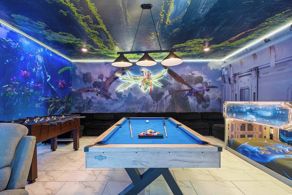 Relax in plush recliners facing a smart TV surrounded by glowing murals — the perfect spot for movie nights and gaming after Disney adventures.