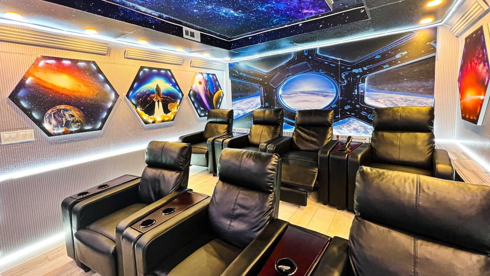 Futuristic space-themed theater room with luxury recliners and LED lighting.
