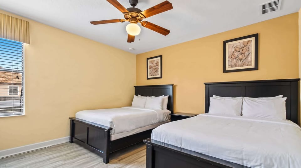 Bedroom featuring two double beds, equipped with its own TV
