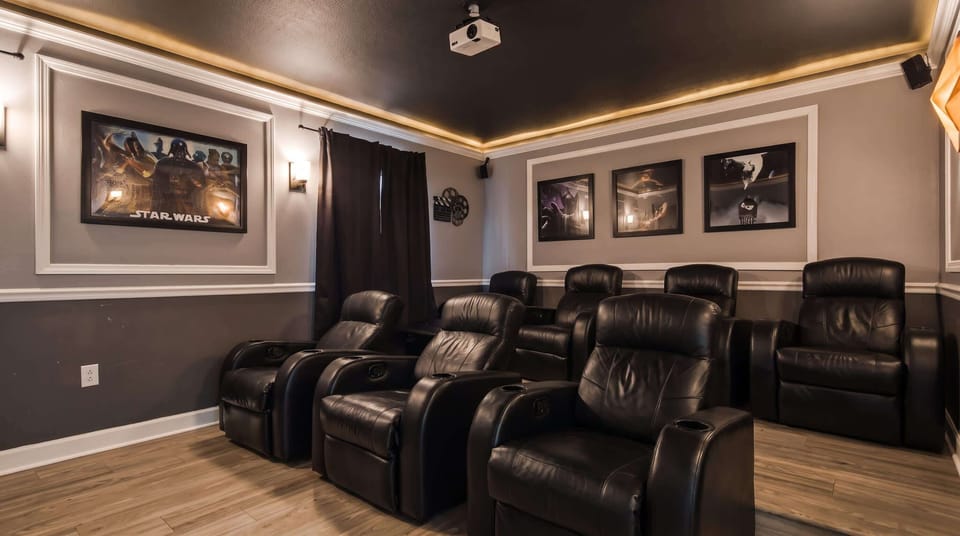Dedicated movie theater equipped with plush seating, a large screen.